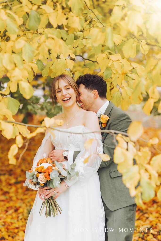 a bride and groom in an autumnal setting for their wedding at De Ver Tortworth Court. wedding hair and makeup by Eviesmakeup