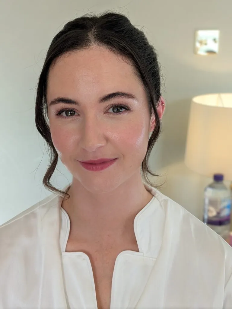 A bride smiling on her wedding morning. Hair and makeup by Evie's makeup