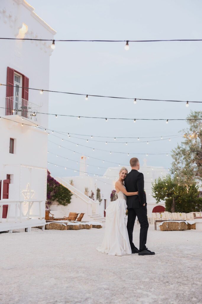 bride and groom at their destination wedding in italy. the bride is looking back at the camera wearing a white dress and her hair in a high bun