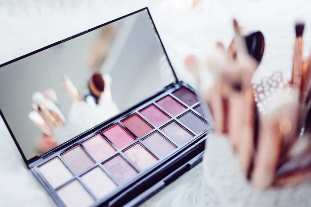 Stock photo of makeup and makeup brushes laid out artistically.