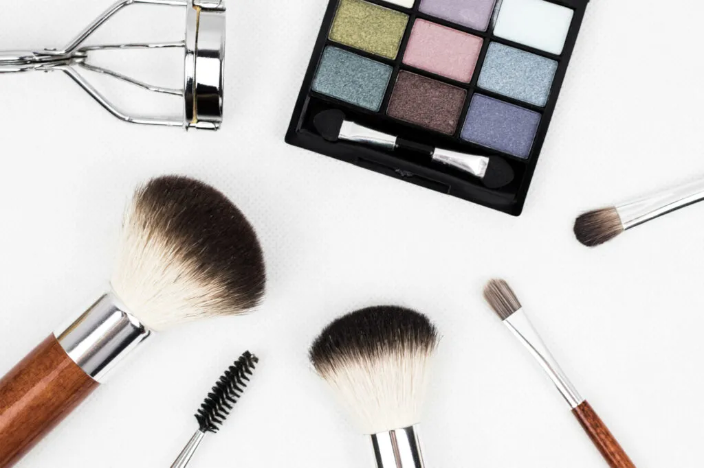 Stock photo of makeup and makeup brushes laid out artistically.