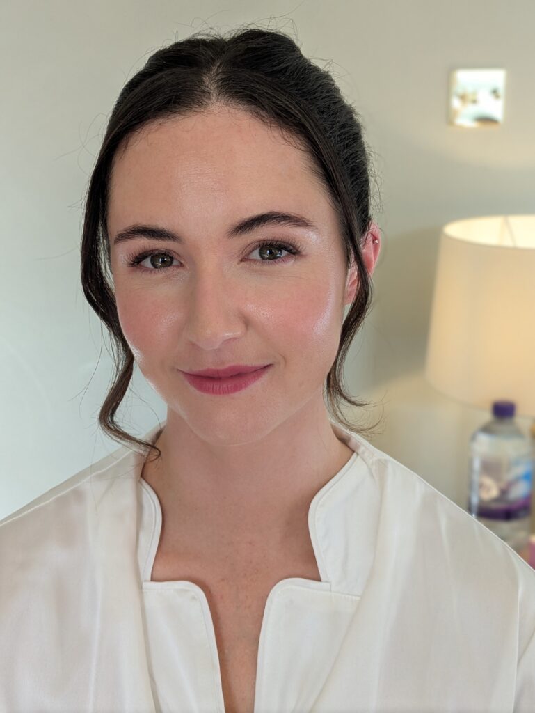 A bride smiling on her wedding morning. Hair and makeup by Evie's makeup