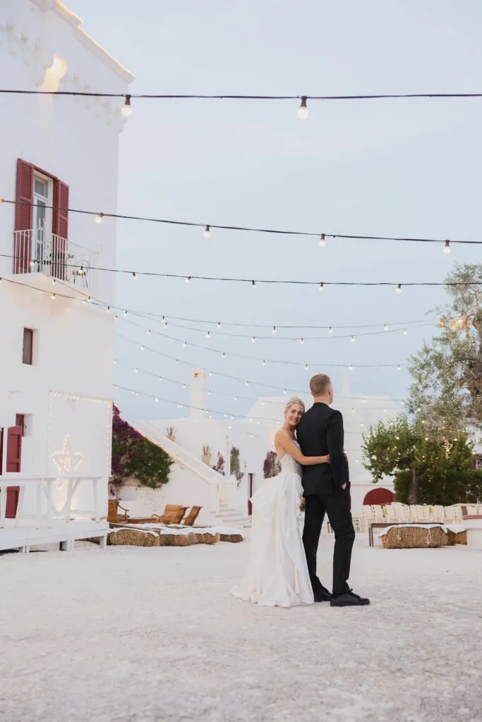 bride and groom at their destination wedding in italy. the bride is looking back at the camera wearing a white dress and her hair in a high bun